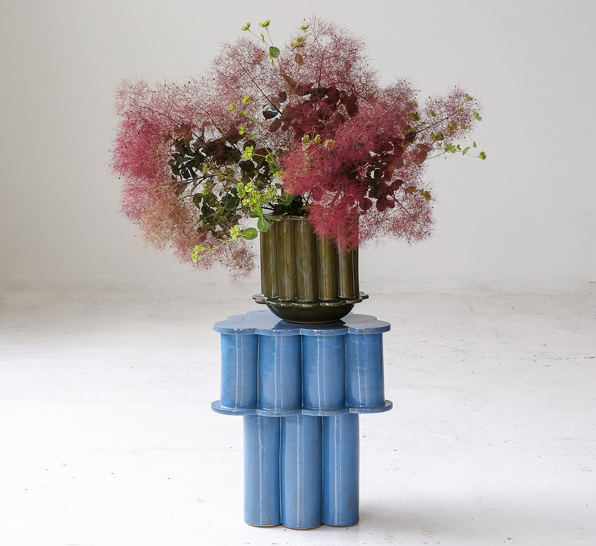 Sculptural blue pedestal and floral arrangement